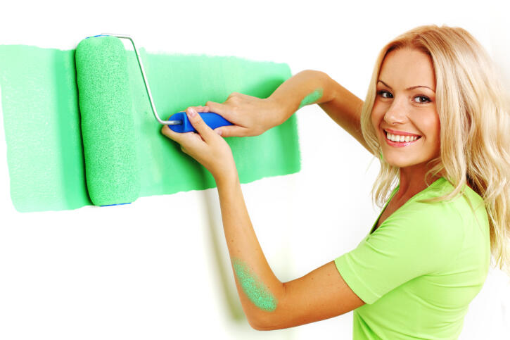mujer pintando pared de color verde