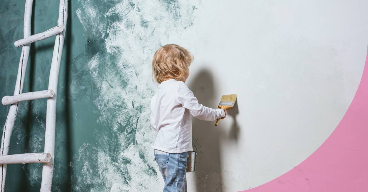 niño pintando pared de una habitación