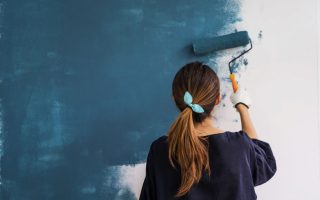 mujer pintando pared de color azul