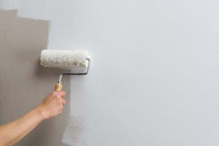 persona pintando pared con rodillo